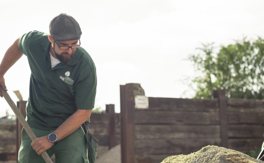 Mann schaufelt Erde auf.